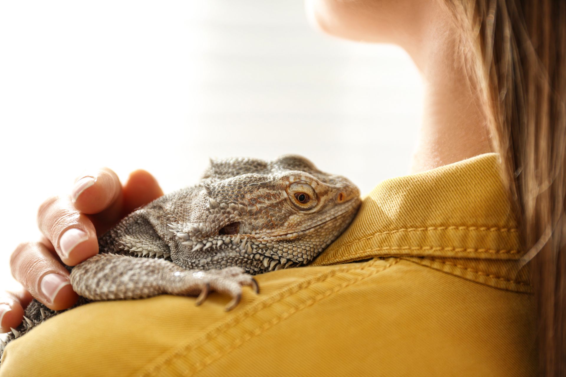 A woman with a lizard on her shoulder