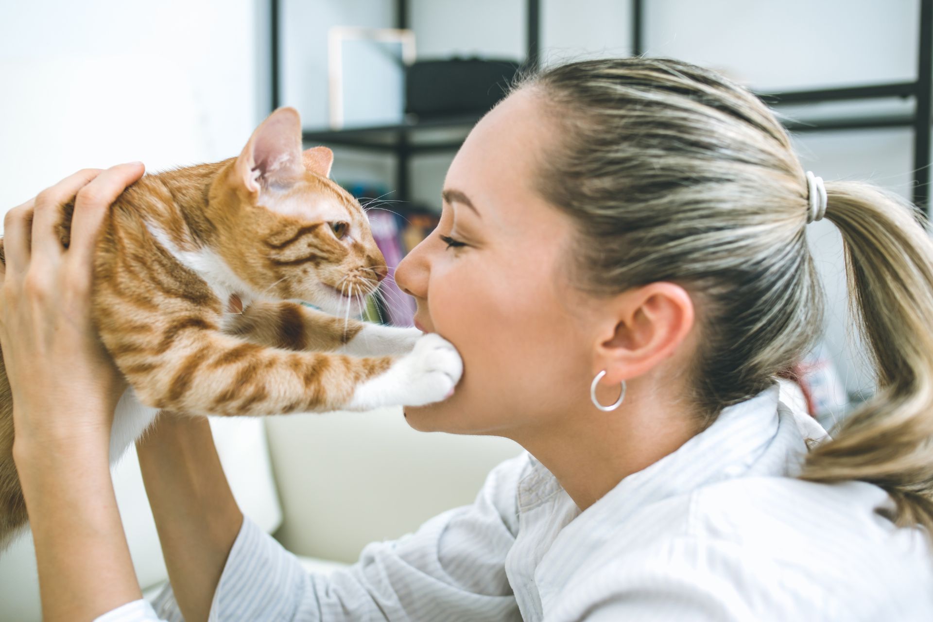 A woman holding a cat to her face