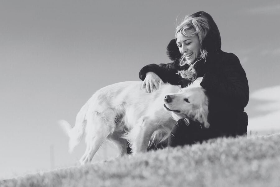 Black and white photo of a woman on a hill with her dog