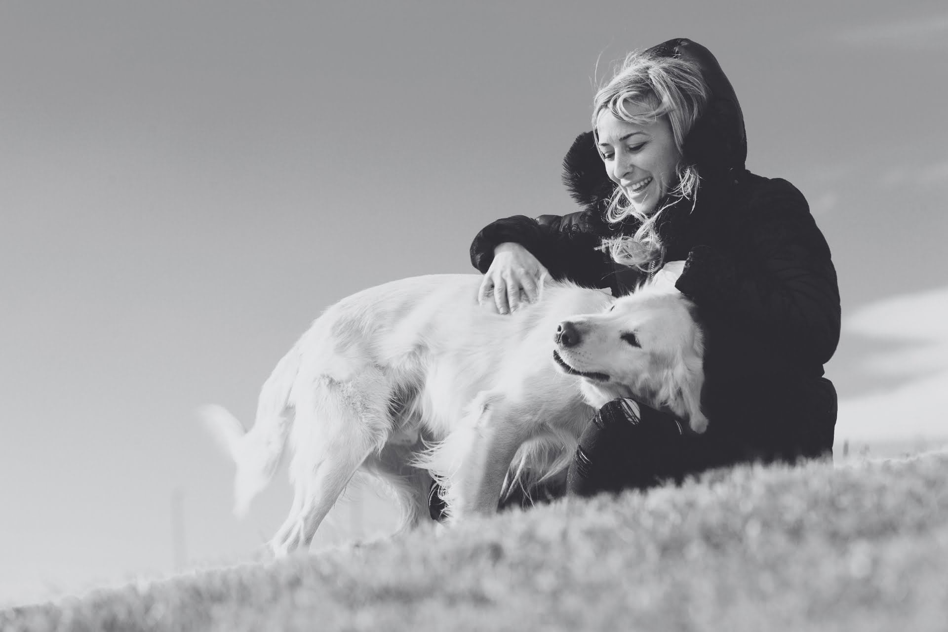 Black and white photo of a woman on a hill with her dog