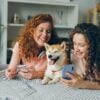 Two women lying on a bed with a dog