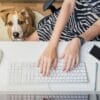 woman on a computer with her dog next to her