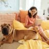 Woman on her bed with a dog next to her